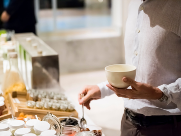 Desayuno de hotel con frutas de temporada, repostería casera, yogures y zumo de naranja, presentado en un buffet cuidado y atractivo.